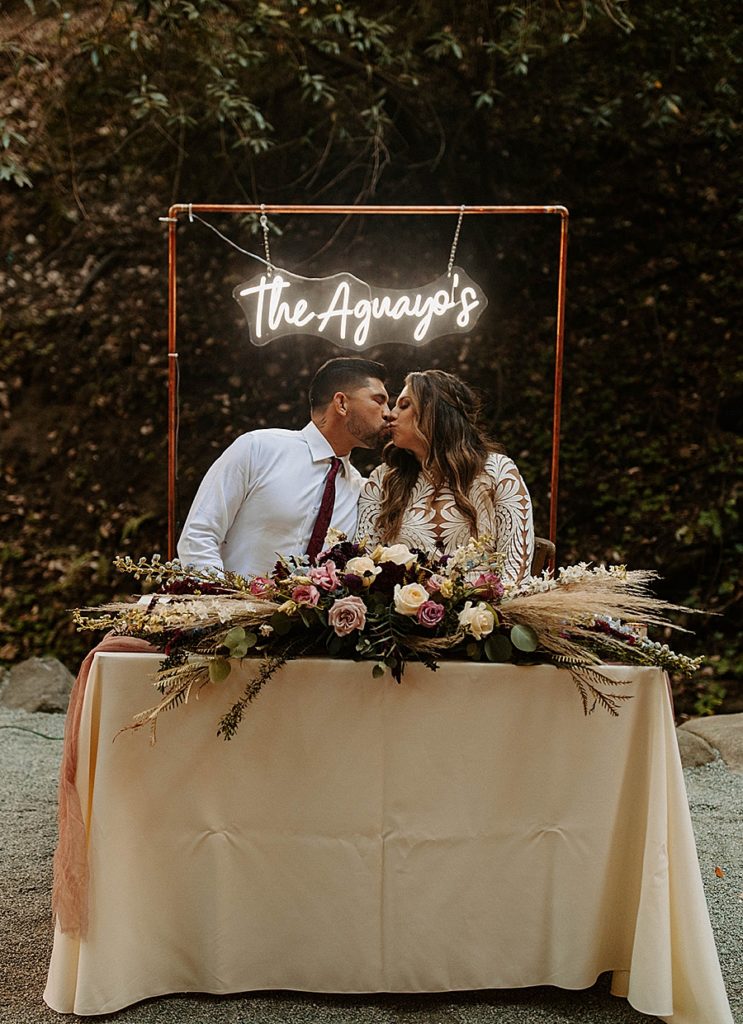 bride and groom table decor with neon name sign